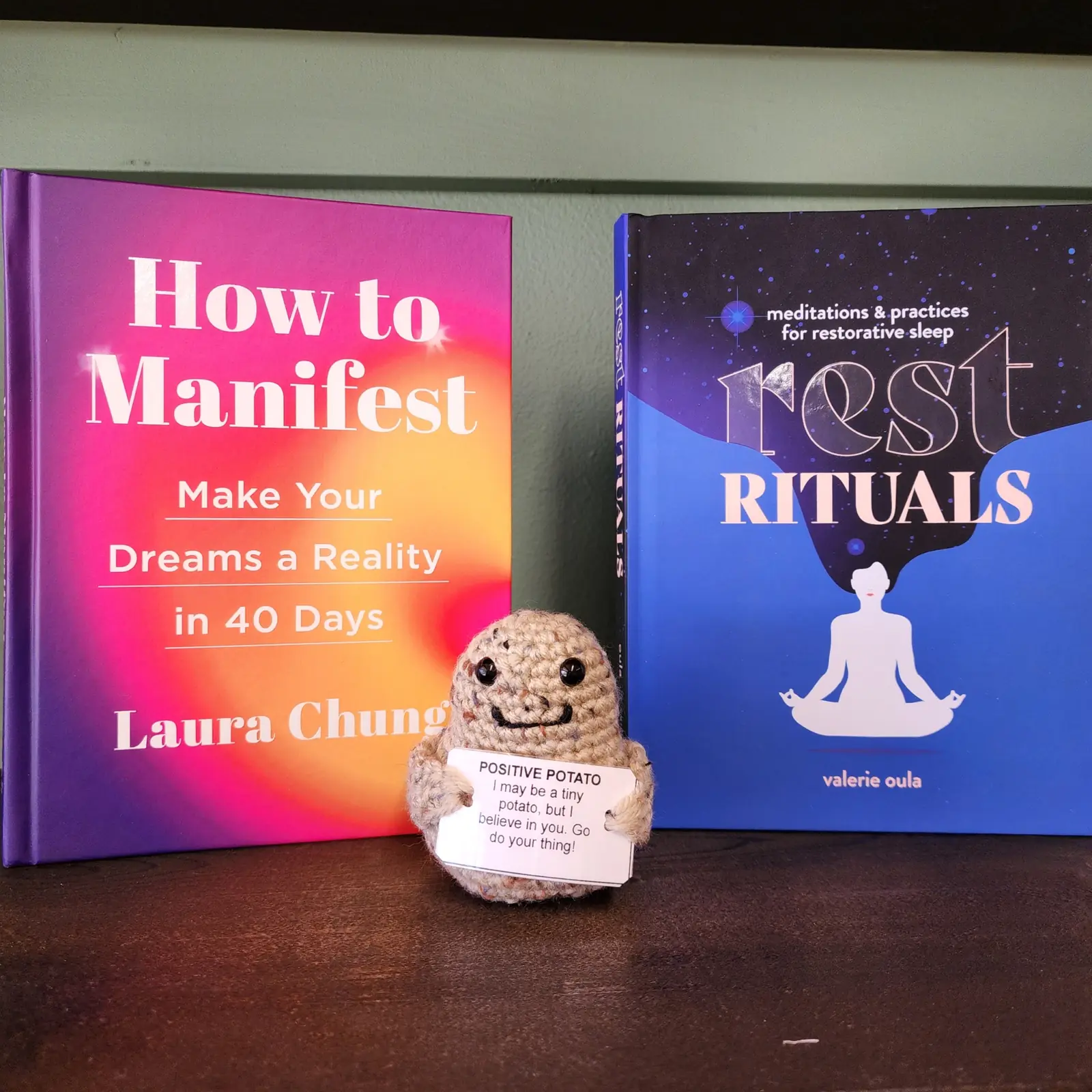 Books on manifesting and rest rituals with a crocheted potato
